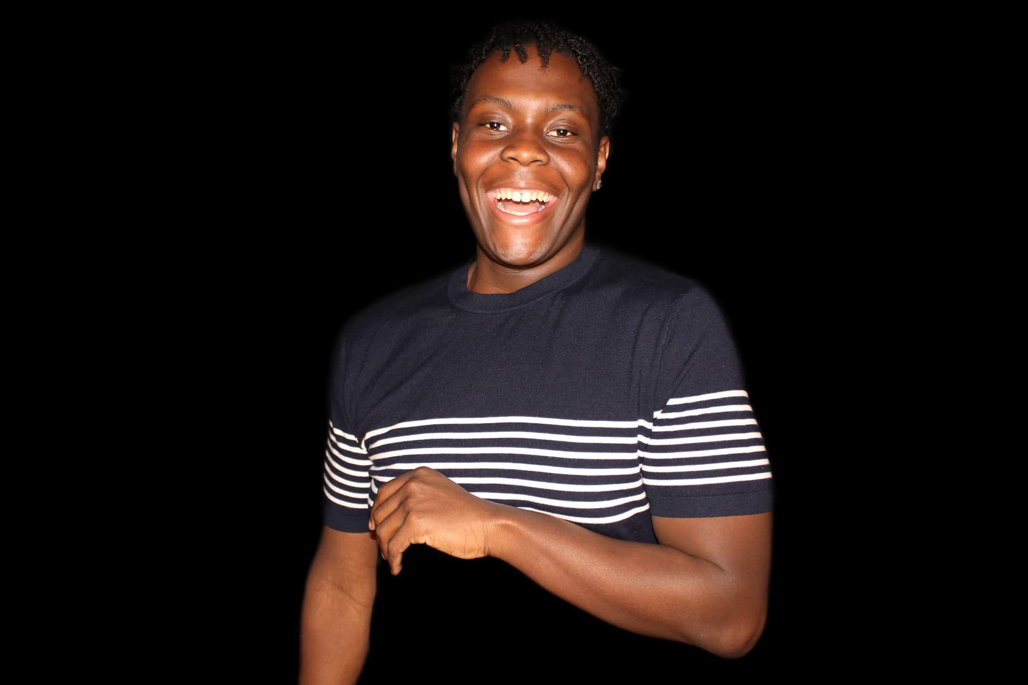 Caleb Jakes smiling in a navy shirt with white stripes
