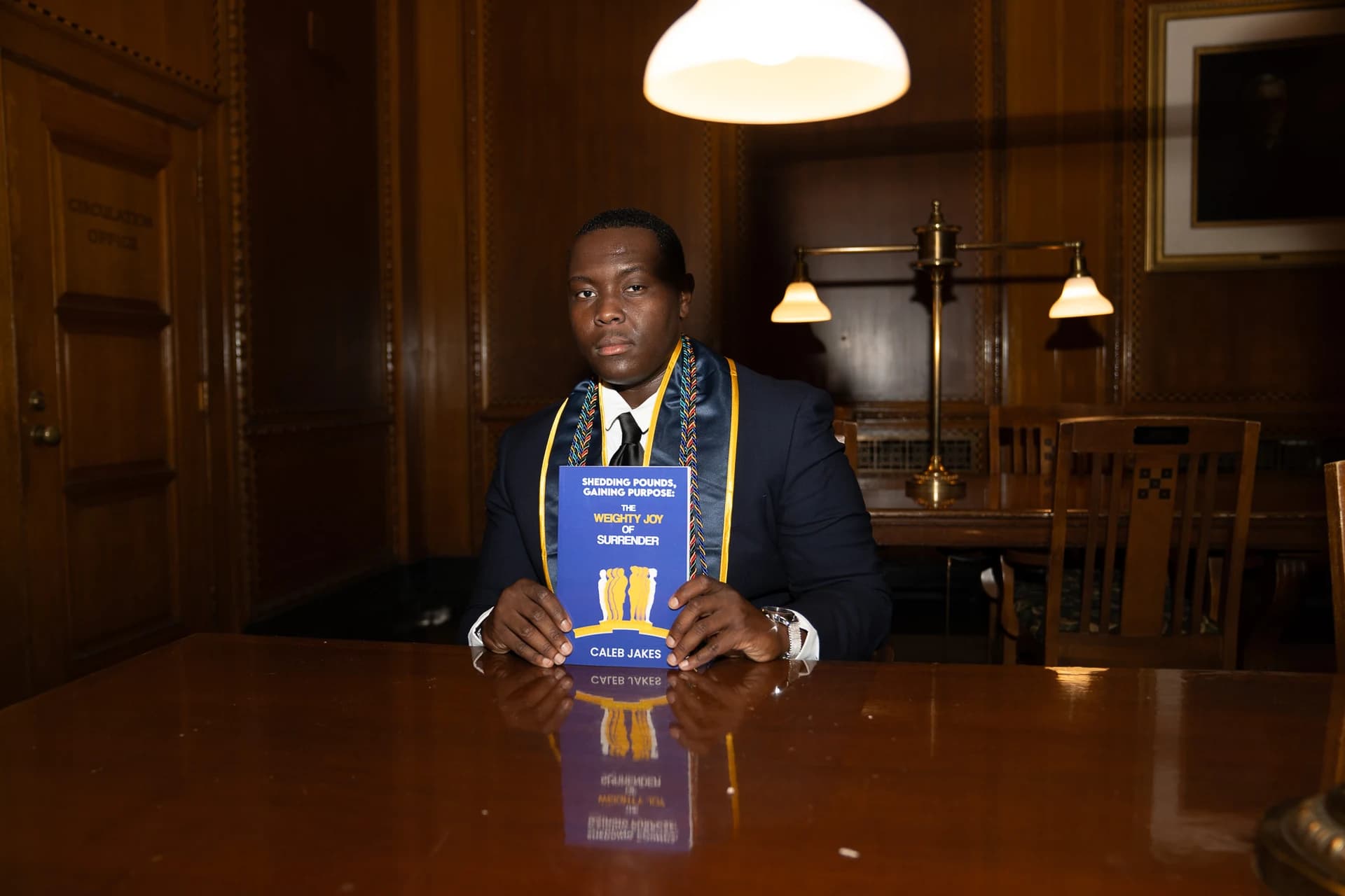 Caleb Jakes in a portrait with his book